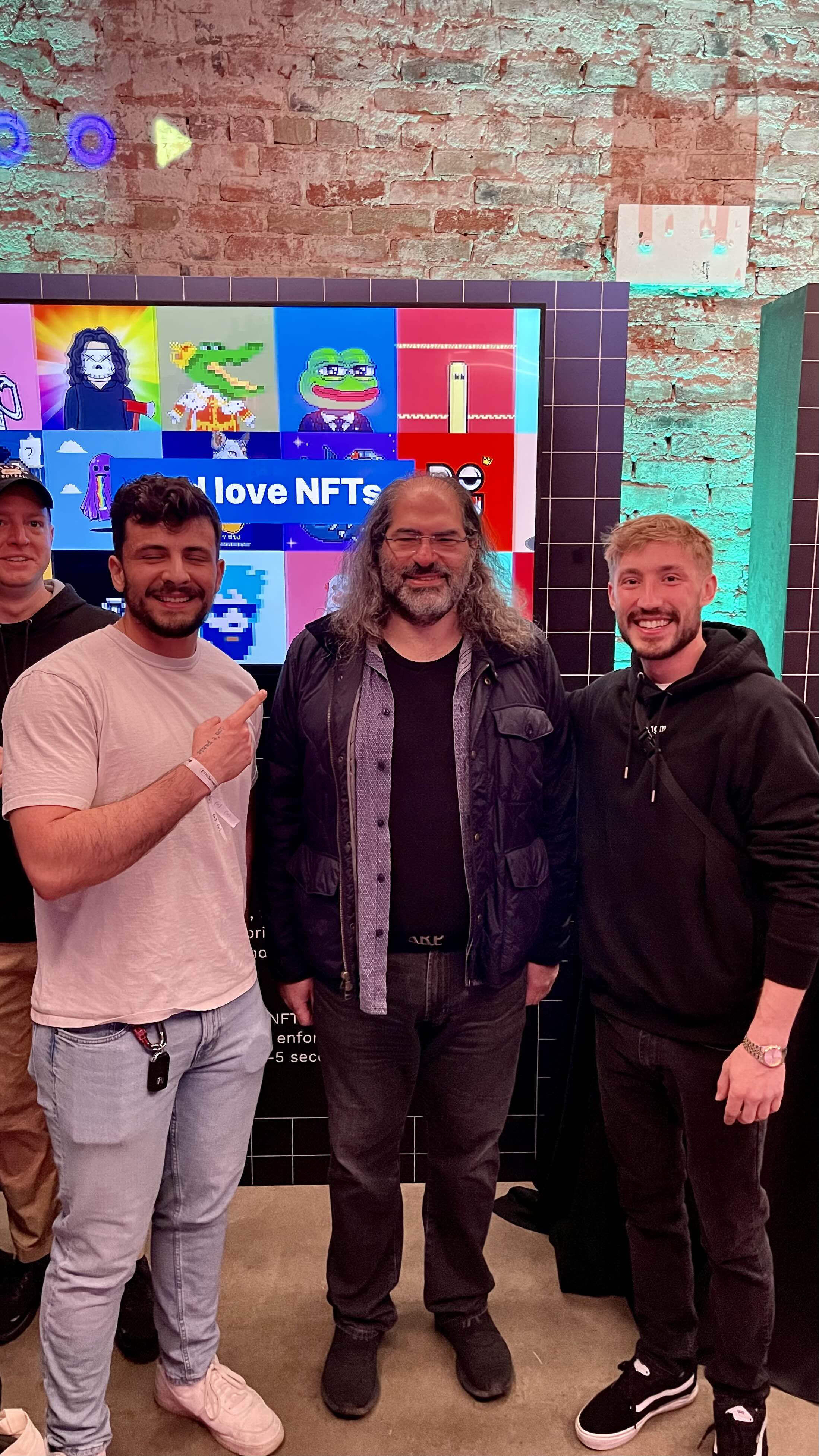 Team at NFT event with display wall